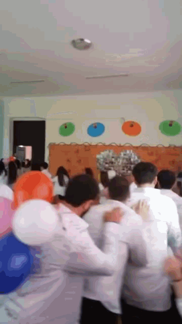 a group of people gathered in a room with balloons