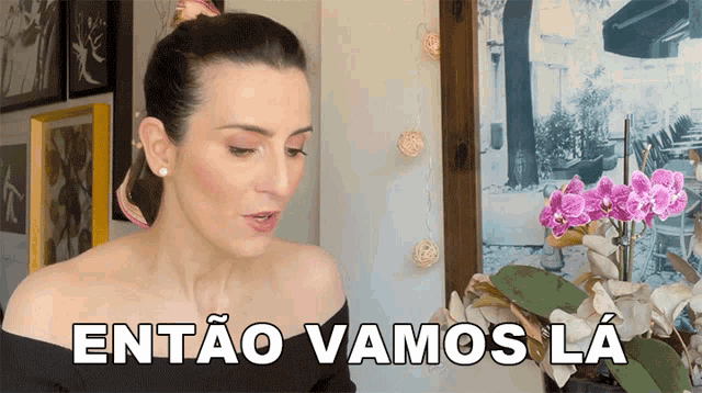 a woman says então vamos la in front of a picture