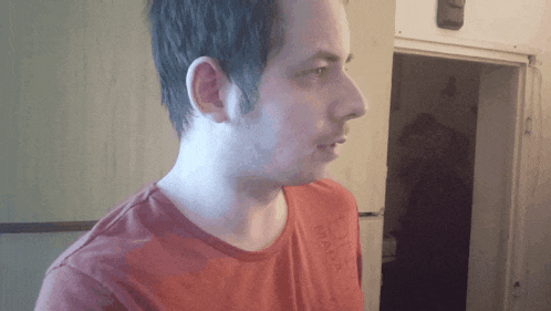 a man wearing a red shirt that says ' milano ' on it