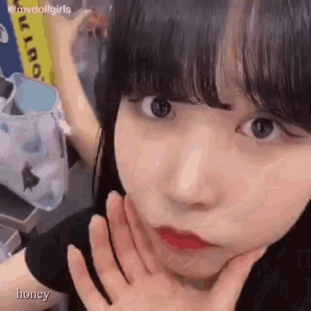 a close up of a girl with her hand on her face .
