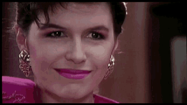 a close up of a woman 's face with pink lipstick and earrings