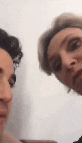two women are making funny faces at the camera while standing next to each other .