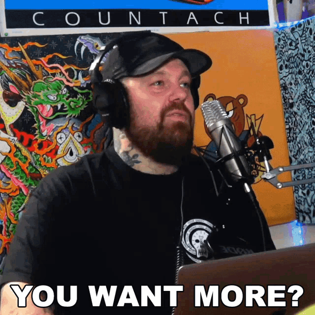 a man wearing headphones stands in front of a microphone and says you want more
