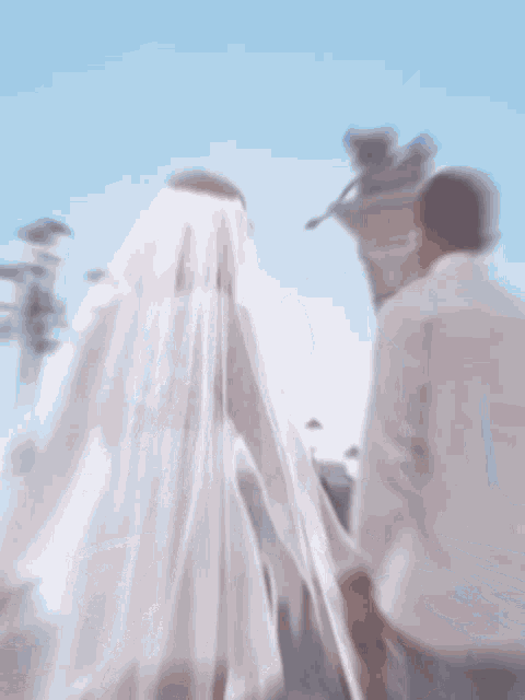a bride and groom holding hands in front of a tower