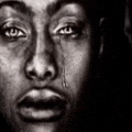 a black and white photo of a man 's face with a tear running down his eye .