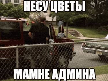 a man in a black shirt is standing next to a red truck with a cooler in the back of it