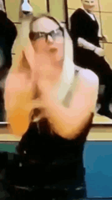 a woman wearing glasses and a black dress is dancing