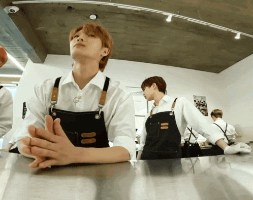 a man in an apron sits at a counter in a restaurant