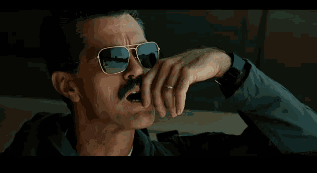 a man with a mustache is wearing sunglasses