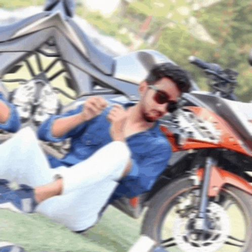 a man wearing sunglasses sits on the back of a motorcycle