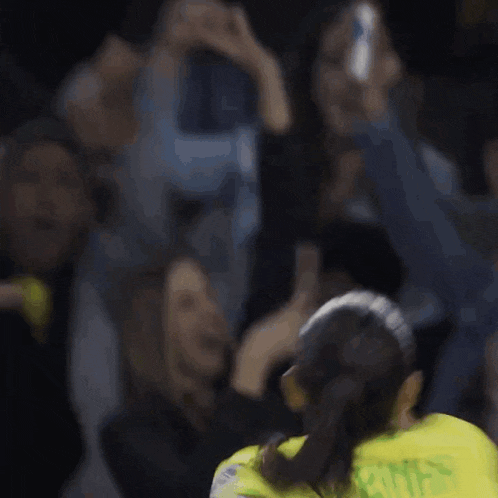 a blurred image of a soccer player wearing a yellow jersey that says ' silva ' on the back