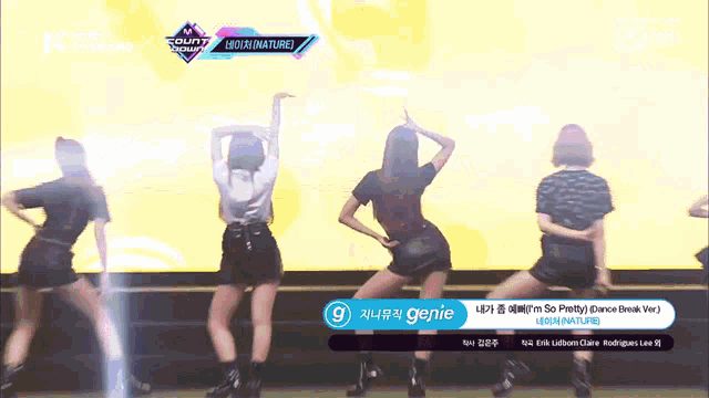 a group of women are dancing in front of a screen that says ' genie '