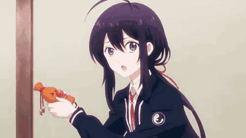 a girl in a school uniform is holding a candy in her hand with the letter e on it