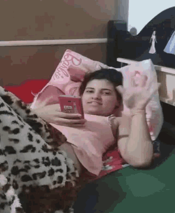 a woman laying in bed with a barbie pillow