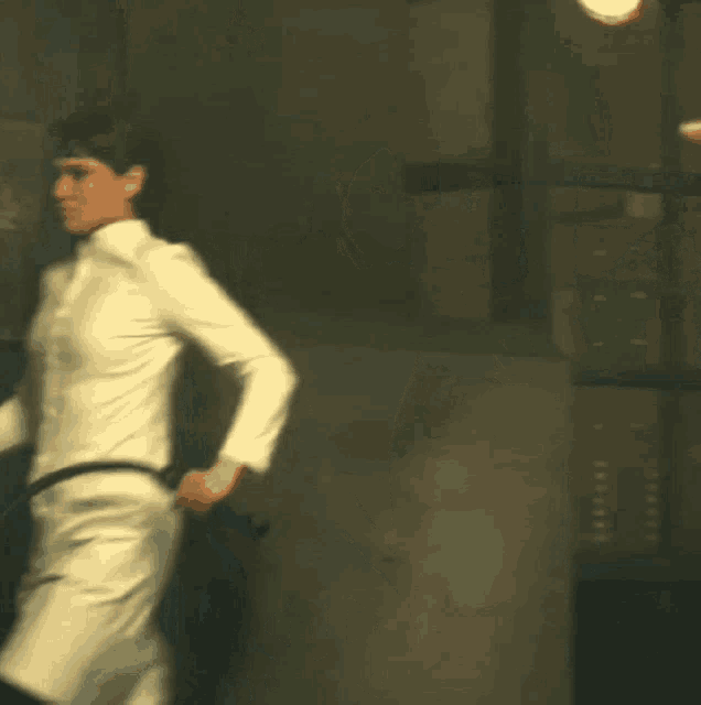 a woman in a white dress is holding a black belt around her waist
