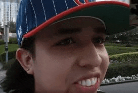 a close up of a man wearing a baseball cap .