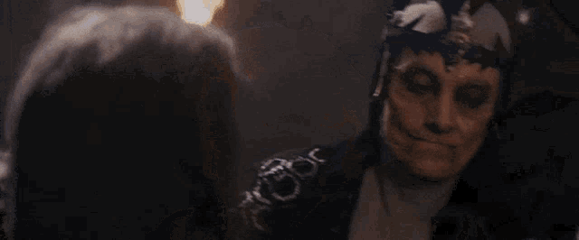a woman with horns on her head is holding a torch in her hand