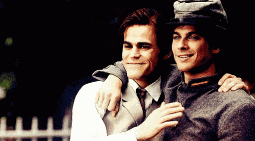 two men are posing for a picture and one has a hat on
