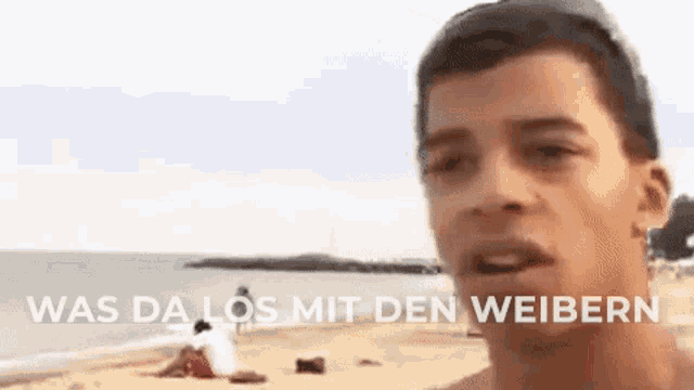a man is standing on a beach and talking to someone .