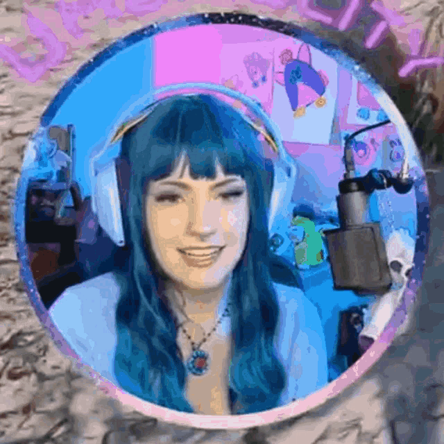 a woman with blue hair is wearing headphones and a microphone .