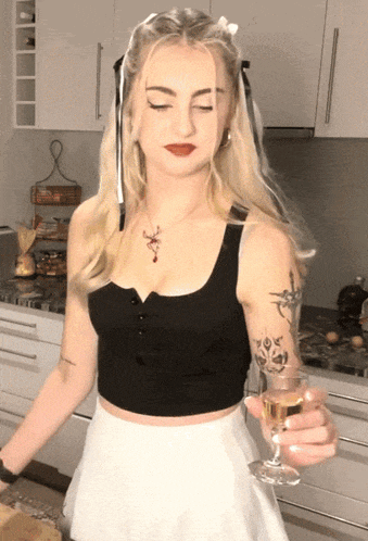 a woman in a black top and white skirt is holding a glass of champagne