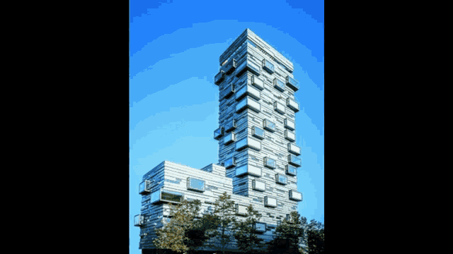 a very tall building with a lot of windows against a blue sky