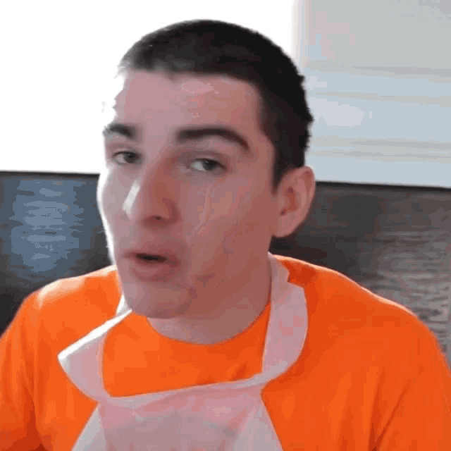 a man wearing a white apron and an orange shirt