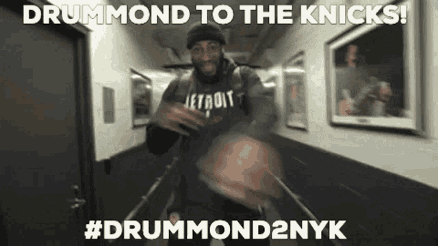 a man is holding a basketball in a hallway with the words drummond to the knicks