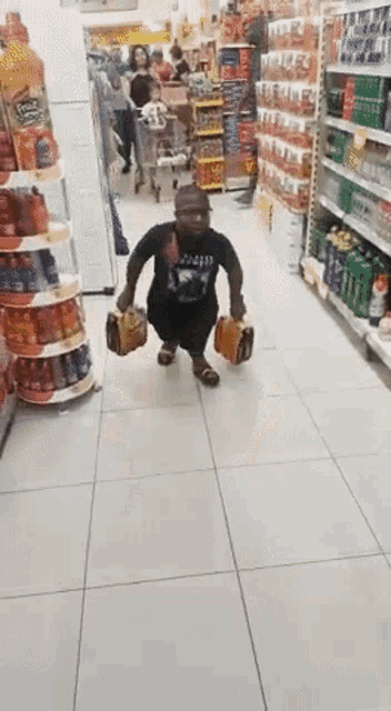 a man in a black shirt is squatting down in a store