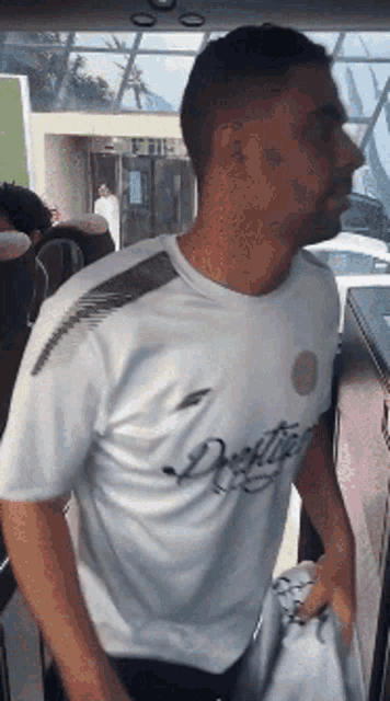 a man wearing a white shirt with the word destiny on the front