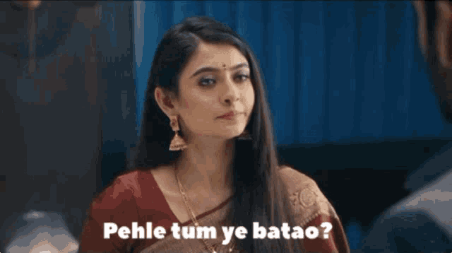 a woman in a red and brown saree says pehle tum ye batao .