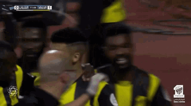 a group of soccer players are celebrating a goal with the number 1 on the screen behind them