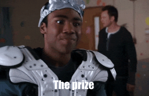 a man wearing a helmet and shoulder pads says " the prize " in front of another man