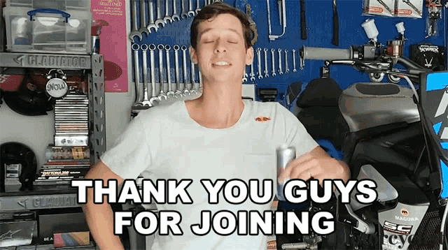 a man in a white shirt says thank you guys for joining while holding a can