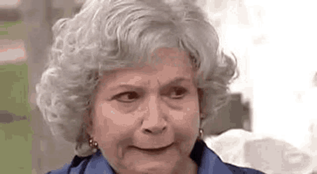 an older woman with gray hair is making a funny face .