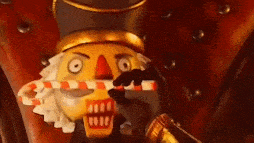 a nutcracker holding a candy cane in his mouth .