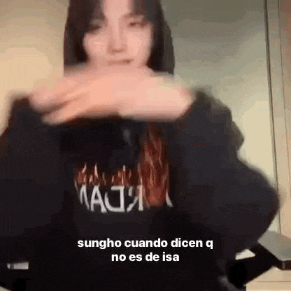a woman in a black hoodie is making a funny face while dancing .