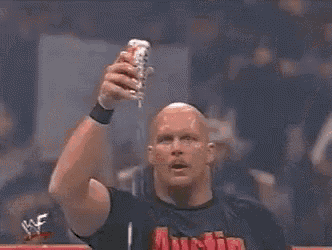 a wrestler is drinking from a can of soda while holding a rope around his neck .