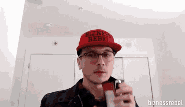 a man wearing a red hat that says bizness rebel on it