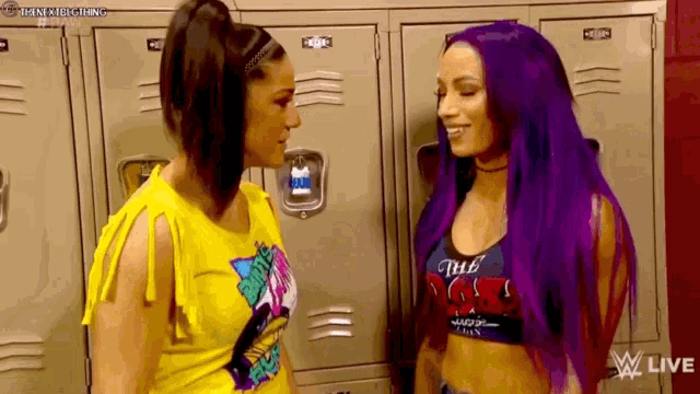 two women are standing next to each other in a locker room and talking to each other .