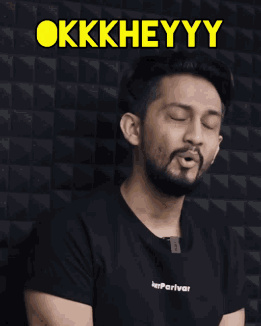 a man wearing a black shirt with the word okkkheyyy on it