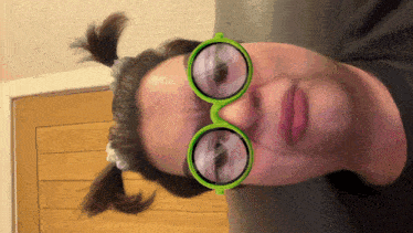 a woman wearing a pair of green glasses makes a face