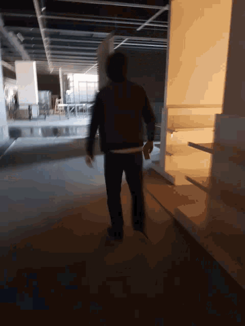 a blurry picture of a man walking in a dark room