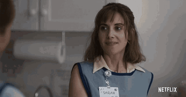 a woman wearing a name tag that says sarah on it