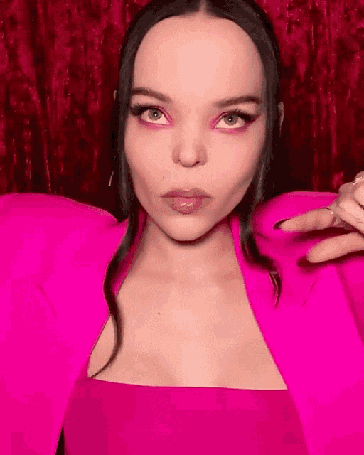 a woman wearing a bright pink jacket and top