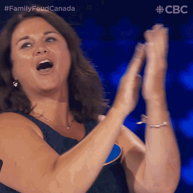 a woman applauds while wearing a name tag that says ' cbs ' on it