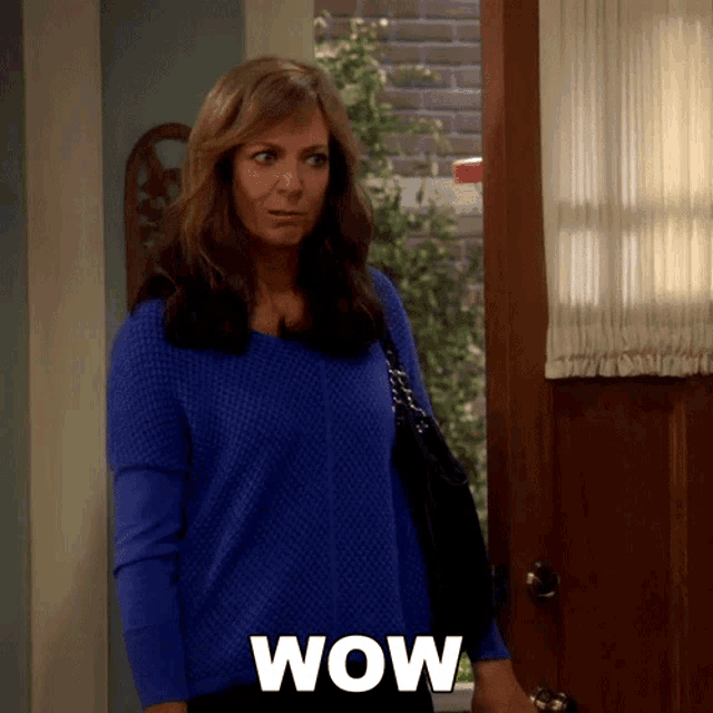 a woman in a blue sweater says wow