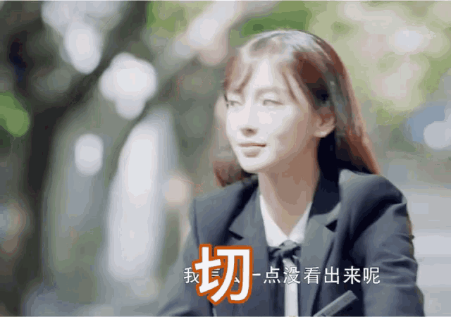 a woman in a suit and tie is smiling with chinese writing behind her