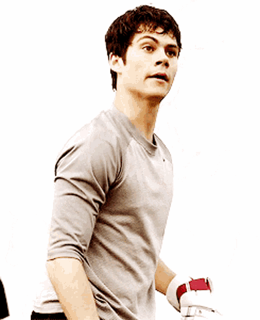 a man wearing a grey nike shirt is holding a red and white glove