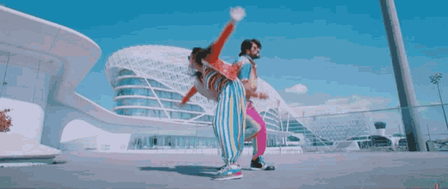 a man and a woman dancing in front of a building